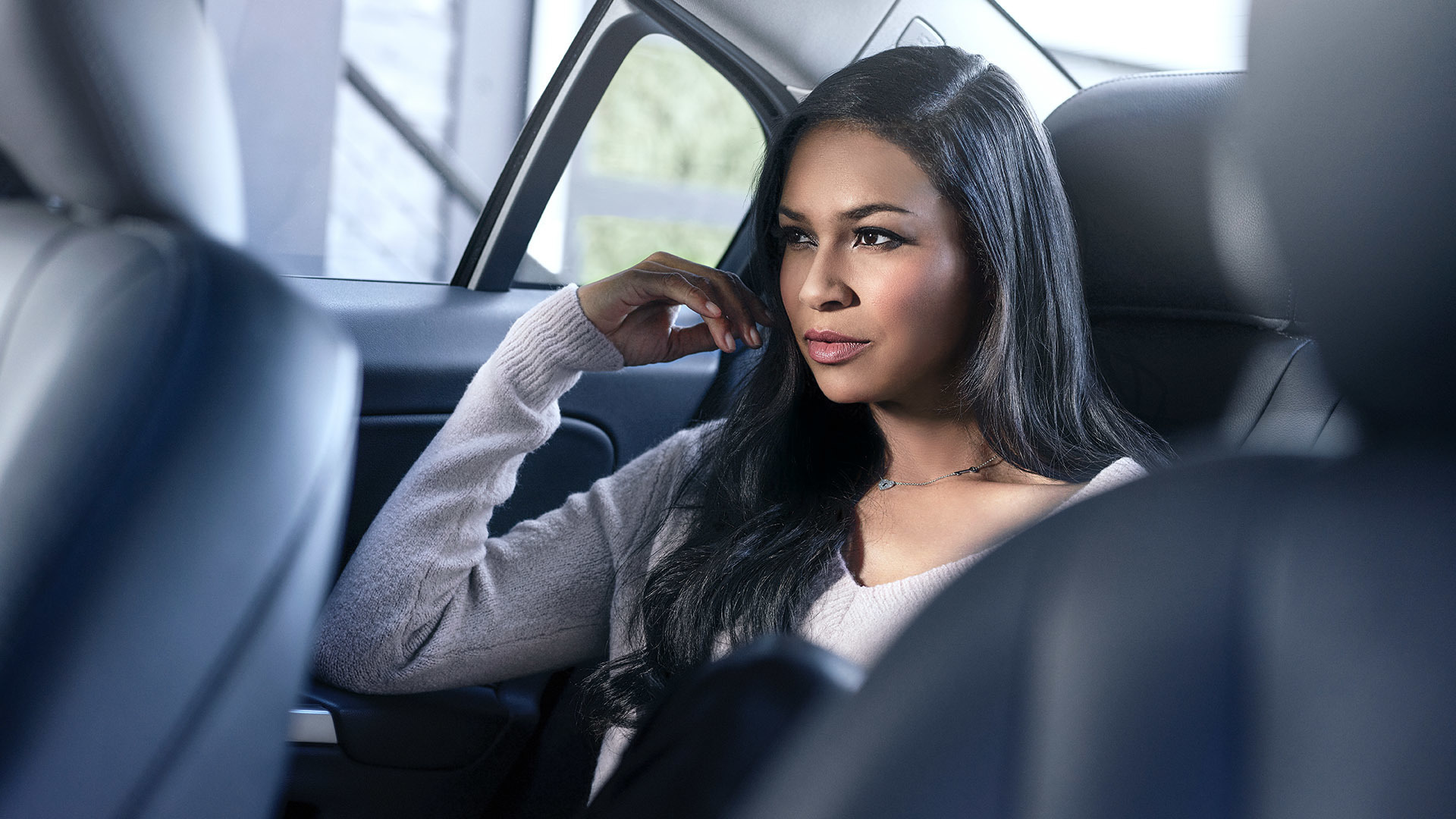 Woman on backseat of car looking along